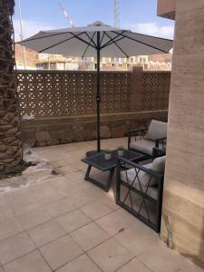 una mesa, una silla y una sombrilla en el patio en Boutique Suite Talia, en Eilat 8 fotos más
