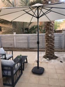 una sombrilla en un patio con mesa y sillas en Boutique Suite Talia, en Eilat