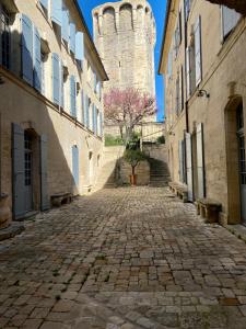 a cobblestone street in front of a castle at L’inattendu in Uzès +39 photos