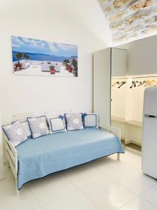 een witte slaapkamer met een blauw bed met kussens bij BLU MARE suite privata & apartment in Terrasini
