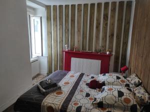 um quarto com uma cama com uma cabeceira vermelha em Enchanté ! Chambres d'hôtes Brocéliande em Mauron