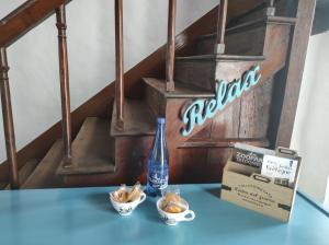 una botella de agua y dos tazones de comida en una mesa en Enchanté ! Chambres d'hôtes Brocéliande en Mauron