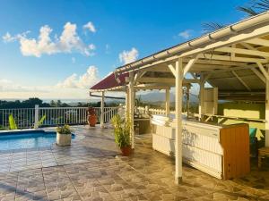 a patio with a swimming pool and a pergola at Appartement charmant à Rivière-Pilote avec piscine privée in Rivière-Pilote