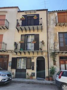 un edificio con dos balcones y un coche aparcado delante de él en casa Ennio, en Ciminna