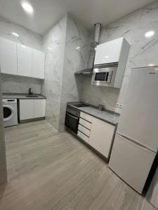 cocina con electrodomésticos blancos y paredes de mármol en APARTAMENTOS CIUDAD DE LAS ARTES Y LAS CIENCIAS, en Valencia