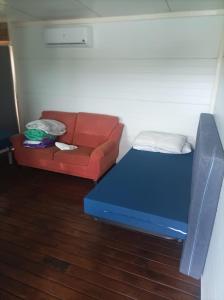 パドロンにあるCrucesinn Albergueの赤いソファ、青いベッドが備わる客室です。