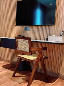 een houten stoel aan een bureau met een tv bij The Palm Suite@Chusan in George Town