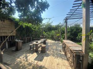 a wooden deck with benches and tables on it at Cat Canh Farm in Ho Chi Minh City
