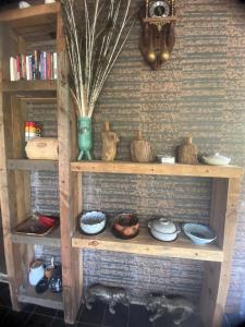a wooden shelf with dishes and vases on it at Cat Canh Farm in Ho Chi Minh City