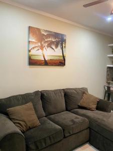 a couch in a living room with a painting on the wall at Departamentos Ada's in Puerto Peñasco