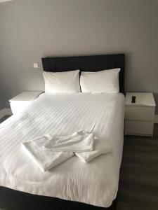 a white bed with two towels sitting on it at Twelve - Boutique Guest House -Galway City Centre -6 Bed En-Suite - Free Parking in Galway