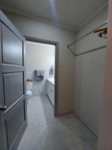a bathroom with a door and a toilet and a sink at Departamentos Ada's in Puerto Peñasco