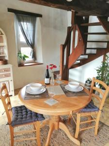 a wooden table with chairs and a wooden staircase at La Vieille Ferme in Donnay