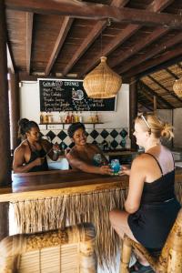 un homme et une femme assis dans un bar dans l'établissement Jungalow, à Gili Trawangan