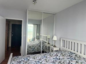 1 dormitorio con cama y espejo grande en Les pieds dans l'eau, en Plérin