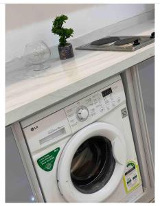 a washing machine under a counter with a plant on top at استديو حي النزهه in Jeddah