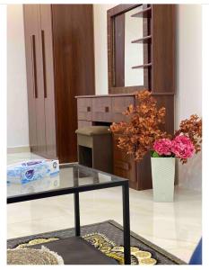 a living room with a glass table and flowers at استديو حي النزهه in Jeddah