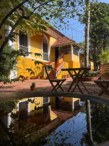 een weerspiegeling van een geel huis in een plas water bij Casa Do Leão A 150 year Old Portuguese Home in Nerul