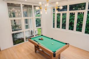 a pool table in a room with windows at พูลวิลล่ากรุงเทพ ลาดพร้าว in Bangkok