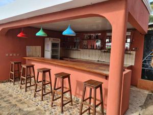 a bar with wooden stools in a restaurant at VILLA FPC in Antsakomboena