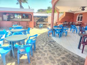 a patio with blue tables and chairs in a restaurant at VILLA FPC in Antsakomboena