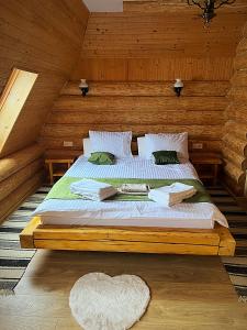 een slaapkamer met een bed in een blokhut bij Pensiunea Casa Cătanelor in Leordina