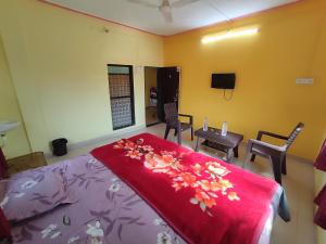 a bedroom with a bed and a table and chairs at Shri Krupa Homestay in Diveagar