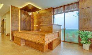 a large bathroom with wooden walls and a large window at Treebo Trend Golden Terminal Kochi Airport in Cochin