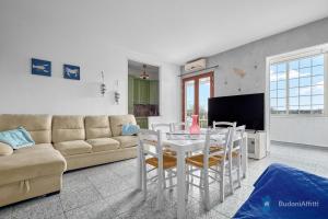 sala de estar con sofá, mesa y sillas en Trilo 350m dalla spiaggia vista mare budoniaffitti, en Budoni