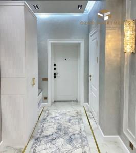 een hal met een witte deur en een tapijt bij Premium 3- roomed apartment near REGISTAN in Samarkand