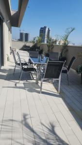 un tavolo e sedie seduti su un patio di penthouse a Herzelia