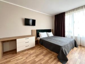 um quarto com uma cama e uma secretária com uma televisão em Sineva Del Sol Apartments em Sveti Vlas