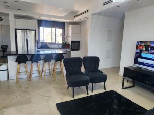 a living room with a kitchen with a table and chairs at penthouse in Herzliya