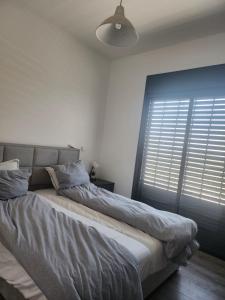 a bedroom with a large bed with a window at penthouse in Herzliya