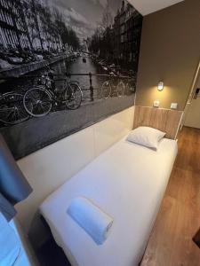 1 cama en una habitación con un cuadro en la pared en Hotel Old Quarter, en Ámsterdam