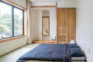a bedroom with a bed and a large window at Hajime Homestay Hue in Hue
