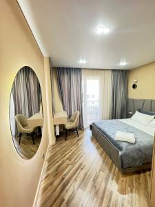 una stanza d'albergo con un letto, un tavolo e delle sedie di Элитный апартамент в центре города Мега центр a Almaty Altre 5 foto