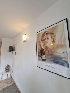 uma TV pendurada numa parede com uma foto de uma mulher em L'Erlon Cosy : hyper centre - proximité gare em Reims