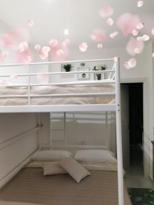 Letto a castello bianco con fiori rosa sul soffitto di La Marchesina House a Misterbianco