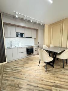 una cucina con un tavolo e sedie in una stanza di Элитный апартамент в центре города Мега центр a Almaty