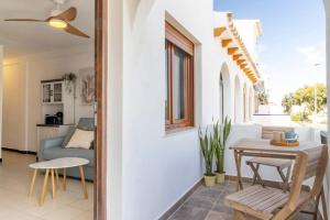 una sala de estar con una mesa y un sofá en Bungalow Pink Torreblanca, en Torrevieja