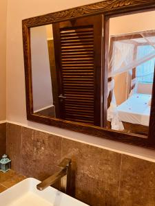 a mirror over a sink in a bathroom at Binta Boutique Hotel in Nungwi