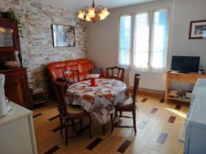 a living room with a table and a couch at Gîte La Maison de LEA in Saint-Agnant-de-Versillat