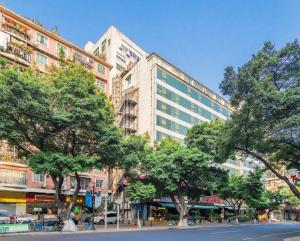 a city street with trees in front of a building at Borrman Hotel - Guangzhou Beijing Road Pedestrian Street Donghu Subway Station in Guangzhou
