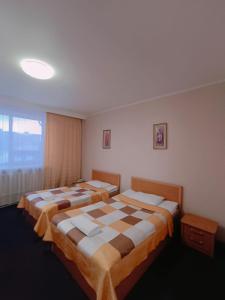 1 dormitorio con 2 camas y ventana en Altyn-Adam Hotel, en Astana