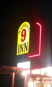 a sign on top of a building with a red light at National 9 Inn in Tonopah