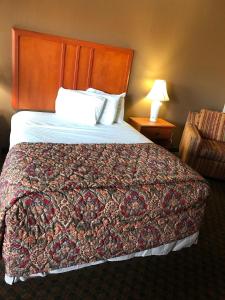 a hotel room with a large bed and a chair at National 9 Inn in Tonopah