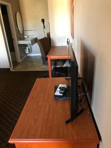 a room with a desk with a television on a table at National 9 Inn in Tonopah