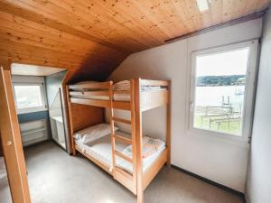 a bunk bed in a room with a window at Strandbad Steckborn mit Herberge, Camping & Glamping in Steckborn