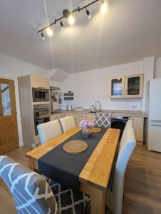 uma mesa de jantar com cadeiras e uma cozinha em New Fully equipped 2 bedroom house. Sleeps 6 em Brockhurst
